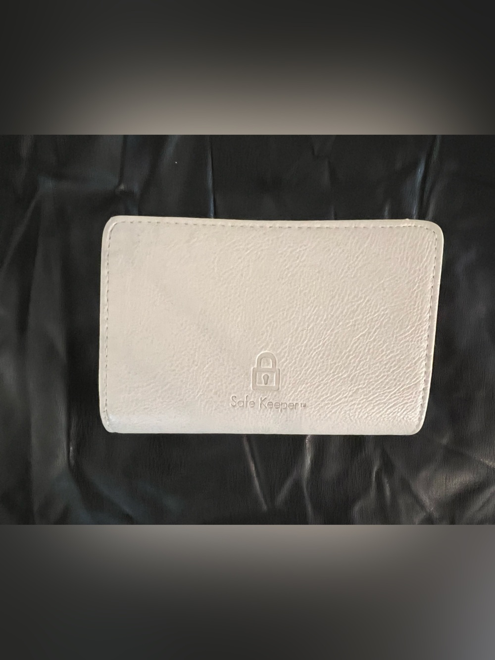 Safe Keeper brand ivory bifold wallet featuring an embossed lock logo